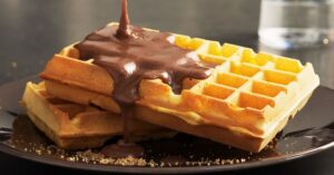 Våfflor med chokladsås på tallrik - läcker frukostidé.