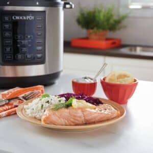 Lax serverad med ris, citron och dillsås framför en Crock-pot