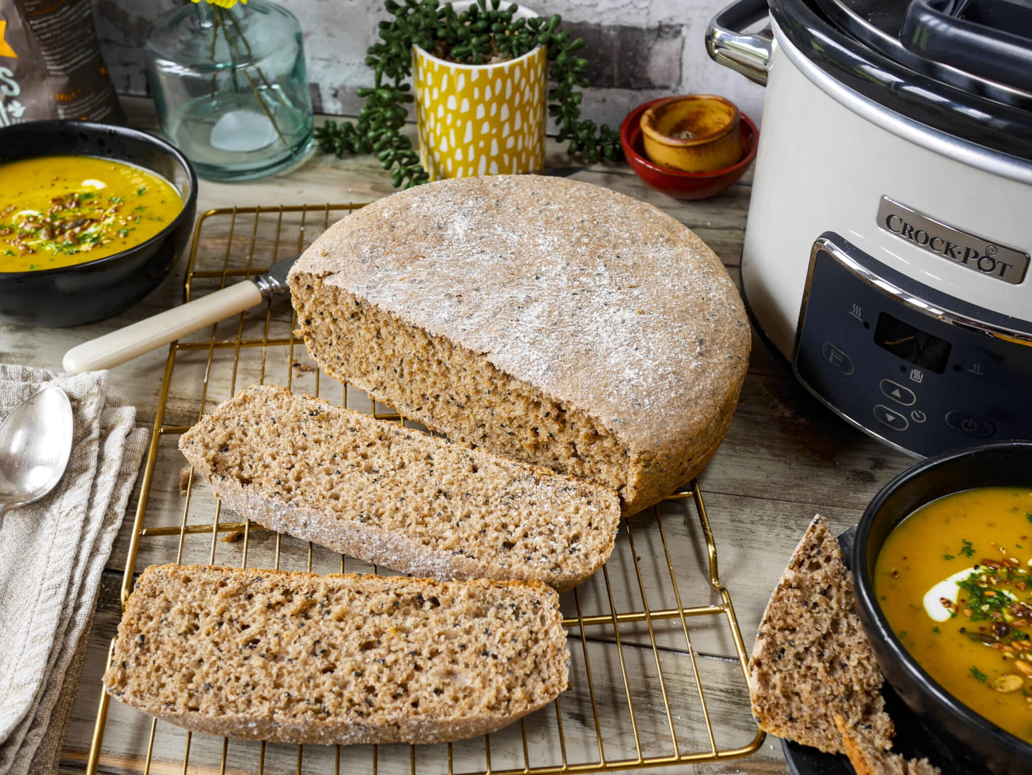 Hemlagat bröd med soppa vid sidan av en slow cooker.